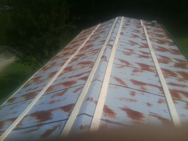 Rusted metal roof panels with new wood purlins before replacement — Storm Damage Roof Repair in Manito by Roofing Brothers