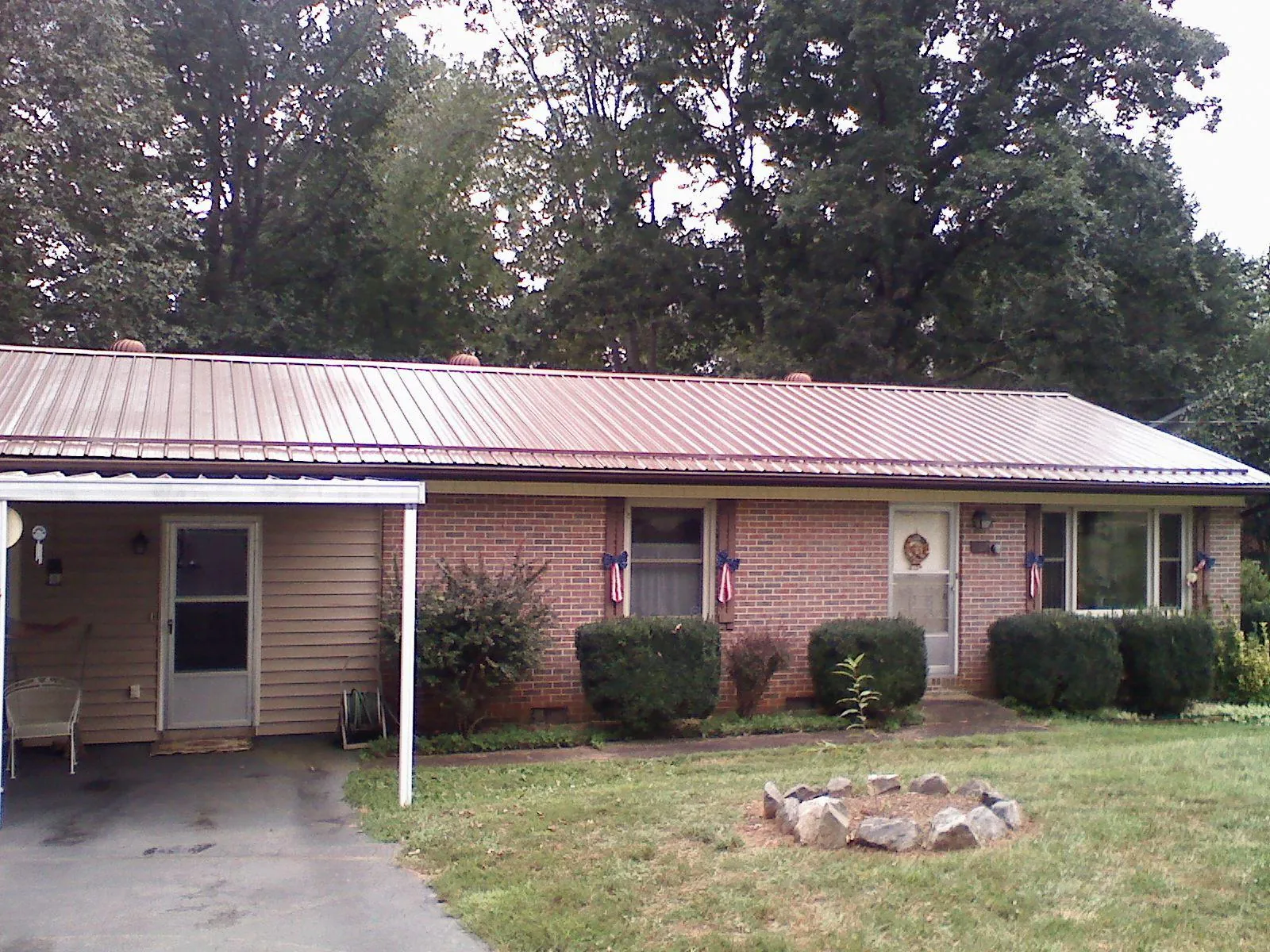 Bronze metal roof and carport on a brick ranch home — Roof Repair work by our crew in Manito